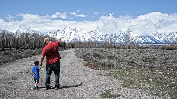 Father pointing to mountains with son